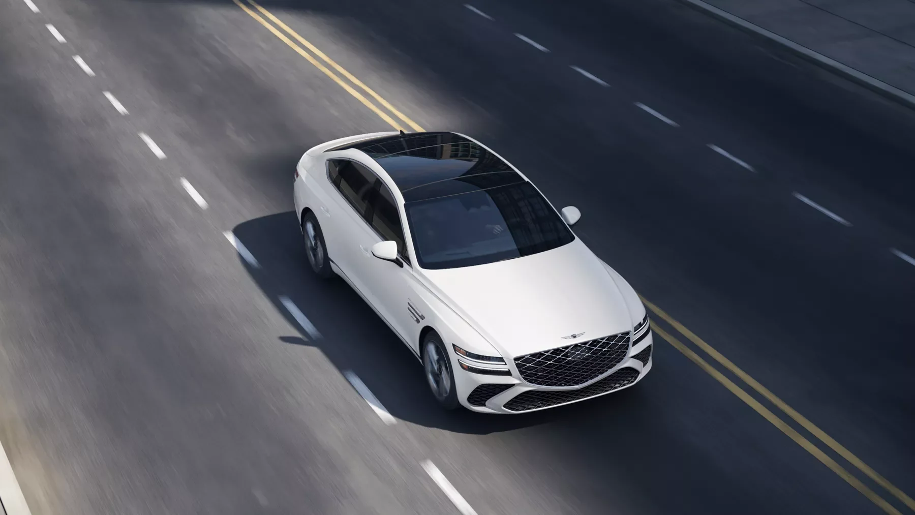 3/4 front passenger overhead view of Genesis G80 in white driving on two lane road